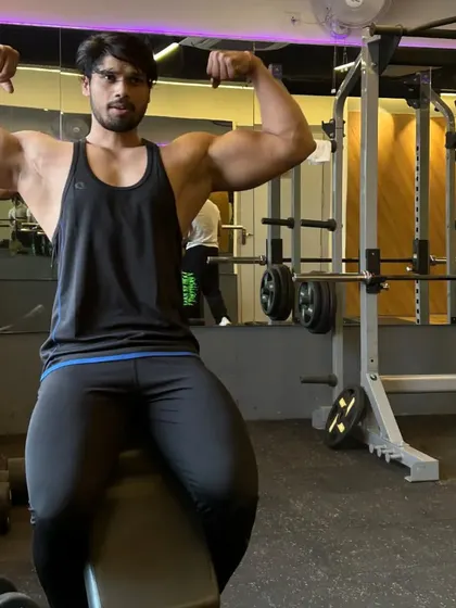A closer shot of the seated double bicep pose.