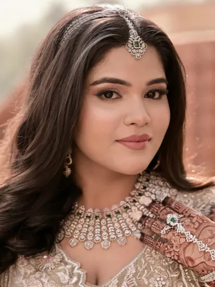 A soft morning bridal look. The makeup is light and airy, with a focus on flawless skin and defined eyes, perfect for her pastel green and diamond jewelry.