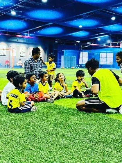Our coaches sit on the ground with the kids to explain drills at their level. This makes the instructions clear and the coaches more approachable.