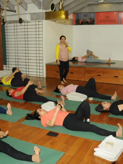 A class of students in a restorative pose. This is a time for the body to absorb the benefits of the practice and for the mind to find stillness.