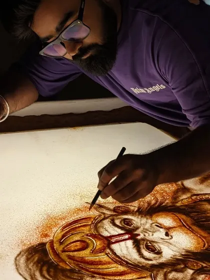 Working in my studio, bringing the powerful image of Hanuman ji to life with sand.