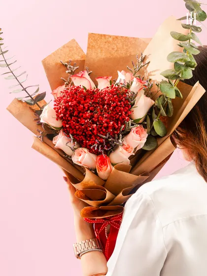 A bouquet where hundreds of mini hearts bloom. This arrangement features a heart made of tiny red flowers, surrounded by soft pink roses, creating a beautiful and intricate symbol of your affection.