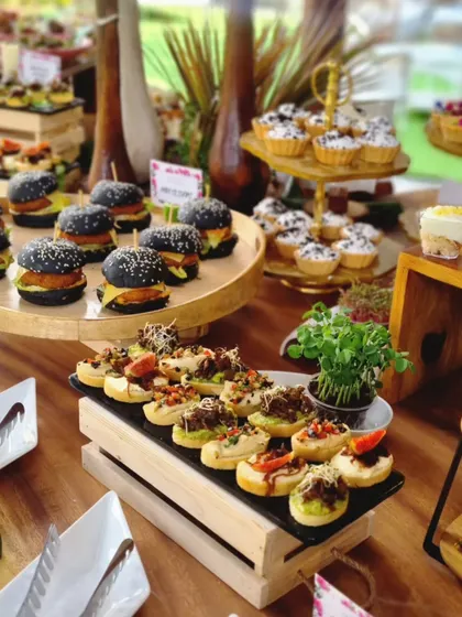 A closer view of a grazing table designed for a store launch, featuring black-bun mini burgers, savory bruschetta, and miniature tarts. We focus on variety to ensure there is a delightful bite for every guest.