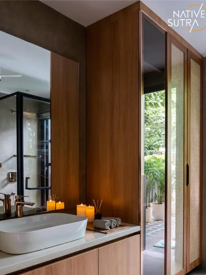 A Zen-inspired washroom where minimalism meets tranquility. This view highlights the warm wood vanity, vessel sink, and large mirror that reflects the rattan-panelled sliding wardrobe doors, creating a harmonious, earthy aesthetic.