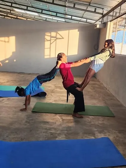 This three-person acrobatic pose is a beautiful display of interconnectedness, where each person's stability contributes to the whole.