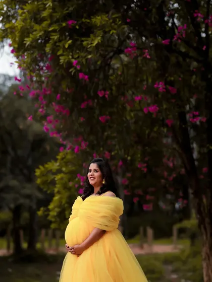 The sheer joy of pregnancy captured perfectly. The yellow off-shoulder gown is a happy and bright choice for celebrating this special time in your life.