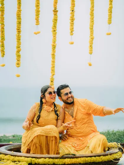 The couple enjoying their Haldi by the sea, pointing out at the beautiful view.