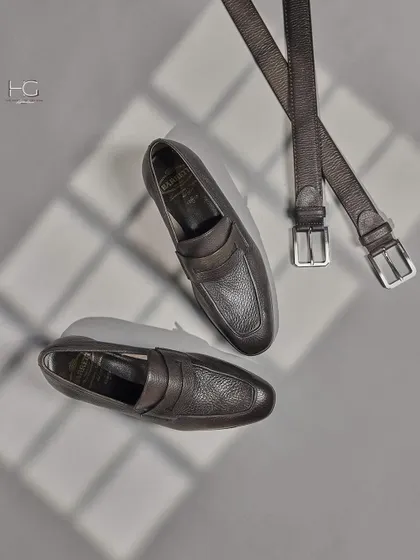 This flat-lay shows the dark brown leather loafers paired with a matching textured belt. Coordinated accessories are key to a polished and sophisticated look.