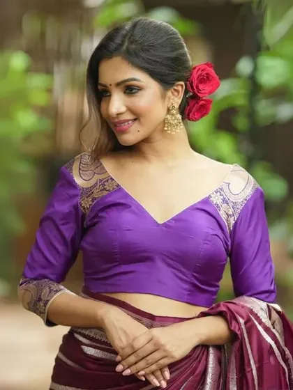 This purple blouse has a V-neckline and three-quarter sleeves with delicate brocade detailing.