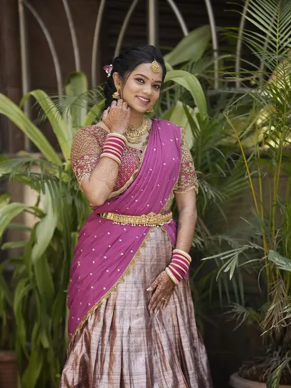 A full-length shot of Teju in her beautiful engagement half-saree, surrounded by greenery.