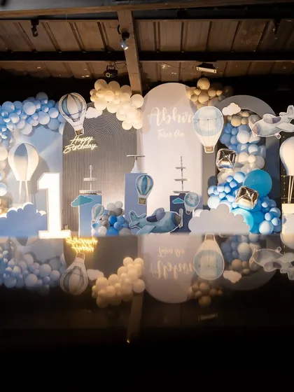 A dreamy "Up and Away" hot air balloon theme in shades of blue and white. The cloud-like balloons and reflective floor create a magical, ethereal feel.
