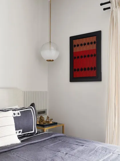 This bedroom from the Madras Home uses a clean, neutral palette with pops of color from a framed textile piece. The design is elegant, understated, and beautifully detailed.