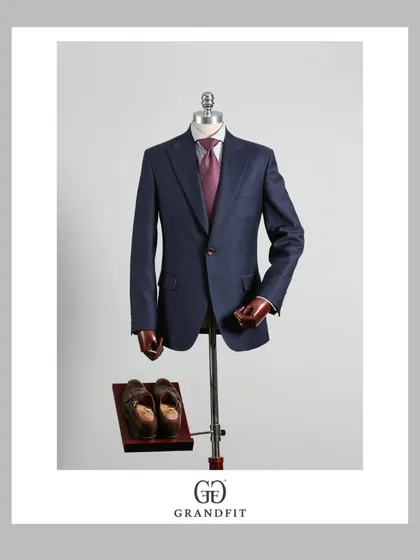 This single-breasted navy suit is a cornerstone of any professional wardrobe. Its versatility and timeless appeal are enhanced by our bespoke fit and quality fabric.