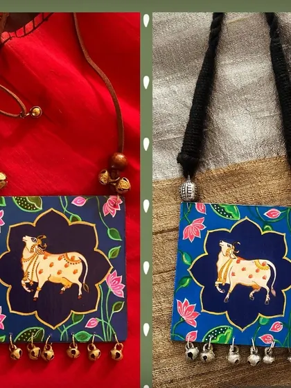 I love how each Kamadhenu, or holy cow, that I paint has its own unique expression. These two pendants, with gold and silver bell accents, showcase the distinct personality that emerges in every handmade piece.