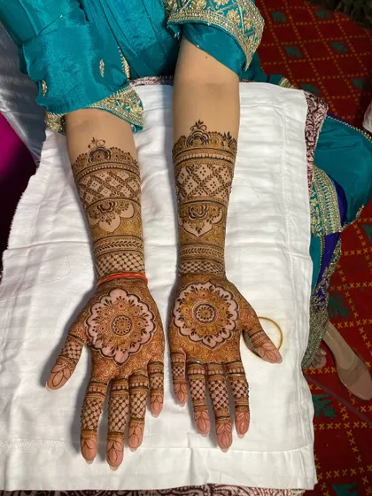 This is a classic Rajasthani `barik` (fine-line) mehandi design. The central mandala on the palm is surrounded by delicate checks and patterns, creating a very traditional and elegant look.