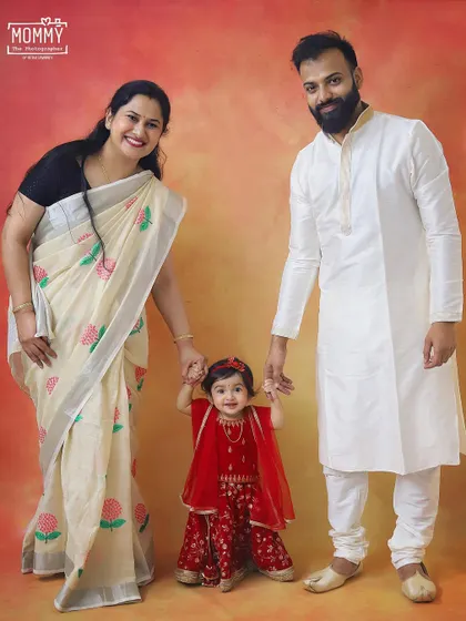 A little Radha with her loving parents. This full-length family portrait from a Janmashtami session shows off their beautiful traditional attire and the sweet family connection.