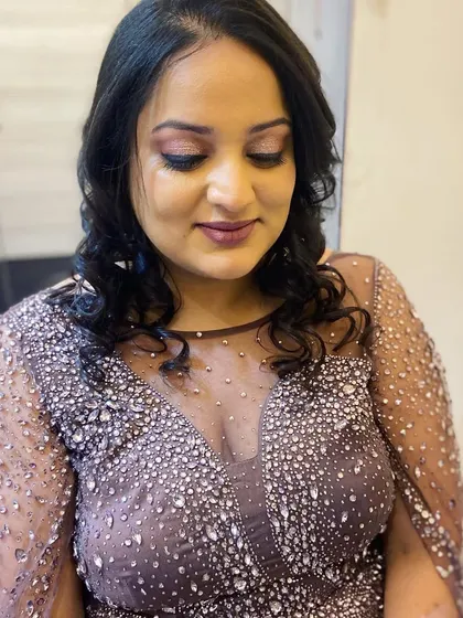 A soft glam party look for a guest, featuring shimmery eyeshadow and a deep mauve lip.