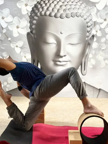 A practitioner uses a yoga wheel and blocks to support an advanced backbend, demonstrating creative use of props.