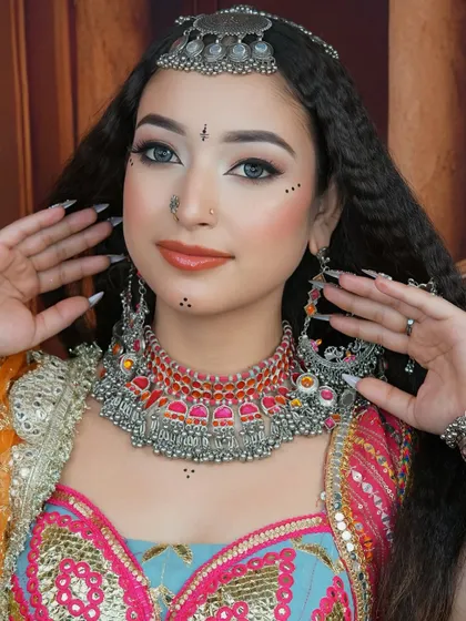 A focus on the stunning oxidized necklace and earrings, which perfectly complement the colorful and traditional makeup.