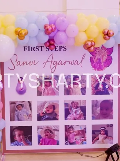 We create personalized photo displays like this 'First Steps' board, which showcases the baby's monthly photos from their first year, framed by a lovely pastel balloon arch.