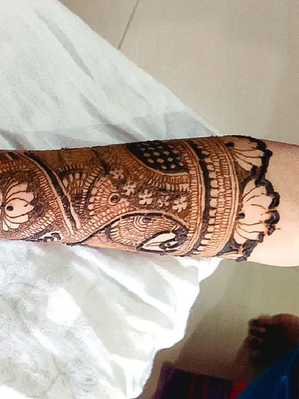 A close-up of a detailed pattern on the forearm. This showcases the fine line work involved in creating complex traditional mehandi designs.