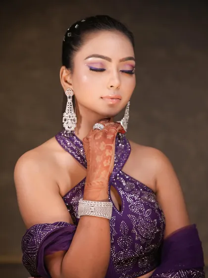 A close up on the makeup, showing the flawless base and the precise application of the purple liner. The soft shimmer on the lid adds a beautiful finishing touch.