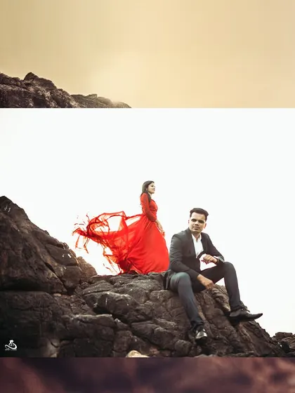 A powerful and elegant shot of a couple on the rocks, with the bride's red dress flowing in the wind.