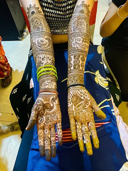 A full bridal design that incorporates personal elements like names, alongside traditional motifs like dholki and peacocks. The result is a piece that is both classic and unique.