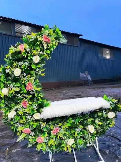A custom-made moon-shaped seat or 'jhoola' decorated with lush greenery and flowers. This is a unique prop I provide for Ganpati decorations or baby photoshoots.