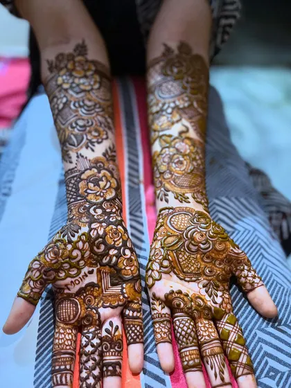 This floral design includes the name "Moin" hidden in the palm, a special touch for the bride.
