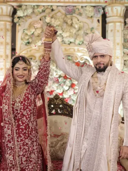 A triumphant moment after the Nikah. The couple raises their hands in celebration, a joyful and iconic shot for any wedding album.