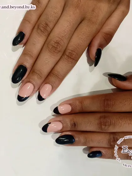A closer view of the asymmetric black French tips on almond-shaped nails. This style is perfect for someone who loves a classic look but wants something a little different.