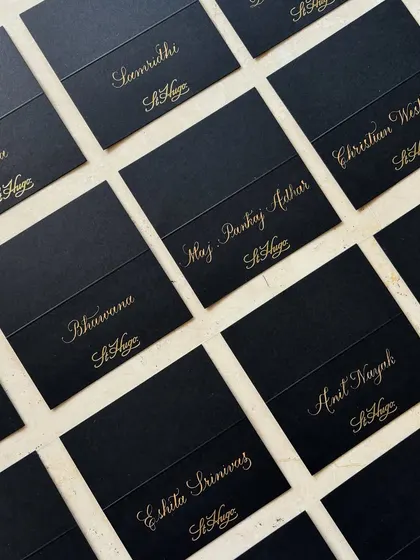 Timeless copperplate calligraphy place cards for a St. Hugo Wines sit-down event at The Ritz-Carlton, Bangalore. These personalized gold-on-black cards added an elevated, formal touch to the gathering.