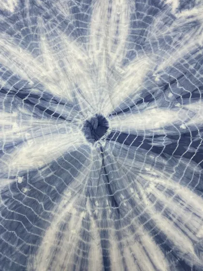 A blue and white tie-dye fabric with a web-like effect. This is a classic pattern that's always in style.