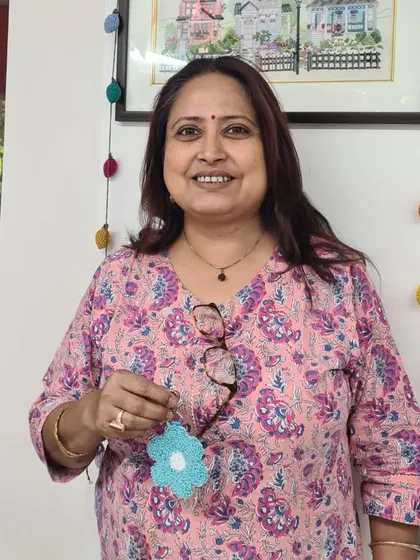 A participant holding her lovely blue flower charm, a simple yet beautiful creation.