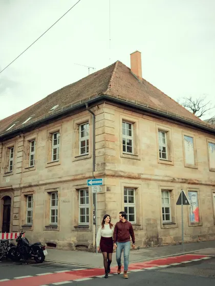 A candid shot of a couple walking hand-in-hand across a street in Germany. This image tells a story of shared journeys and everyday adventures in a beautiful new place.
