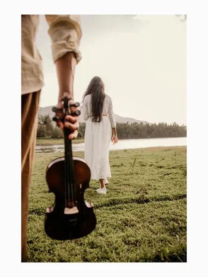 An artistic shot with the violin in the foreground, as the bride-to-be walks towards the lake, creating a story-driven image.