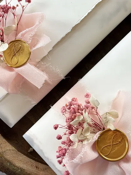 Flat scrolls are stealing my heart. These handwritten letters feature a pastel theme with soft pink silk ribbons, a gold initial wax seal, and delicate dried flowers, making them perfect for a bridesmaid gift.