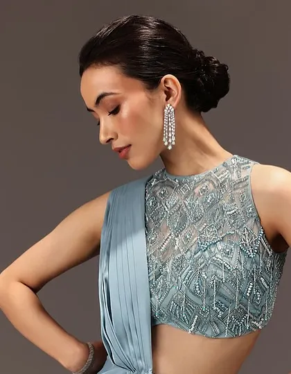 This look demonstrates how a simple low bun can be the perfect foundation for a glamorous evening outfit, allowing the statement earrings and embellished top to shine.