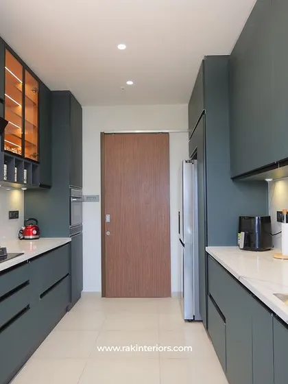 A stunning galley kitchen with matte green-grey cabinets and a white marble backsplash. The long, clean lines and ample counter space make it both beautiful and practical for cooking.