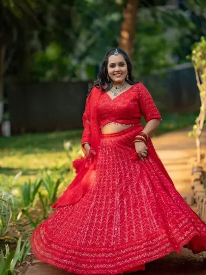 Our client is all smiles, twirling in her red rental lehenga. We love seeing our customers this happy.