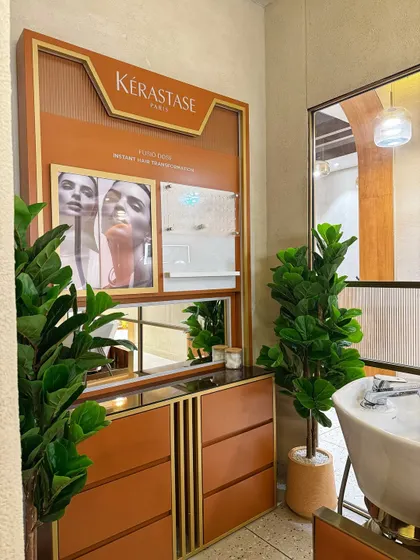 An artificial Fiddle Leaf Fig and another leafy plant add greenery to the product display and washing station at Looks Salon. These faux plants are perfect for high-traffic commercial areas as they require no maintenance.