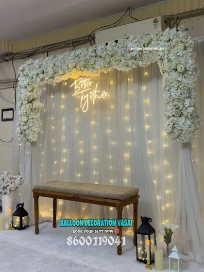 A different angle of our all-white floral arch setup, showing the beautiful interplay of flowers, lights, and sheer fabric that creates a magical atmosphere.