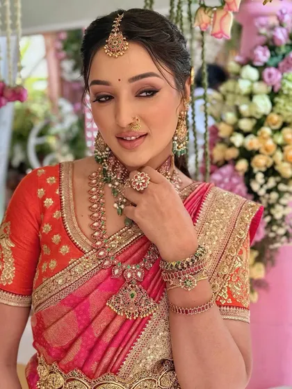 Malavika in a regal, vintage-inspired look. The makeup features a sharp, winged eyeliner and a bold lip, complementing her Sabyasachi saree.