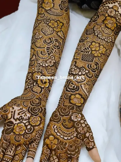 Hiba's beautiful bridal mehndi, with her groom's name, Shehbaz, nestled among the flowers on her palm.