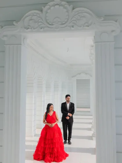 A beautifully framed shot looking through an ornate doorway in a white architectural set, creating a sense of depth and elegance.