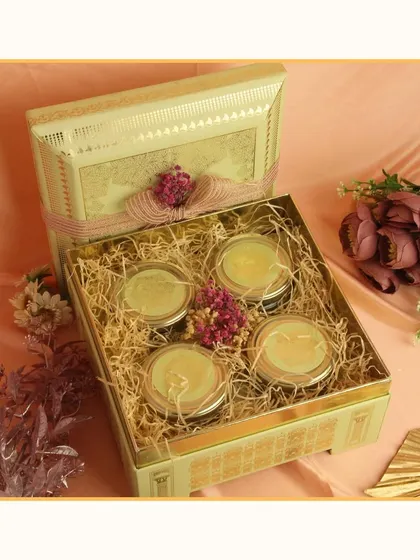 This elegant gift box contains four matching jars, perfect for filling with dry fruits or sweets. It's a versatile and sophisticated option for wedding favors or return gifts.