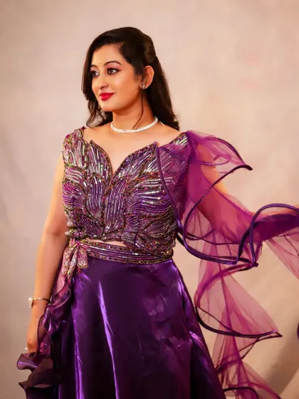 A profile shot of the purple lehenga, highlighting the detailed embroidery on the blouse and the flow of the fabric.