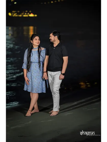 Holding hands and sharing a smile, with the dark water and distant lights creating a beautiful contrast. This is a simple yet powerful image of togetherness.