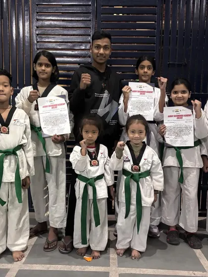 Our champions with their fists up, celebrating their new belts. This picture captures the excitement and sense of accomplishment after a successful belt test.